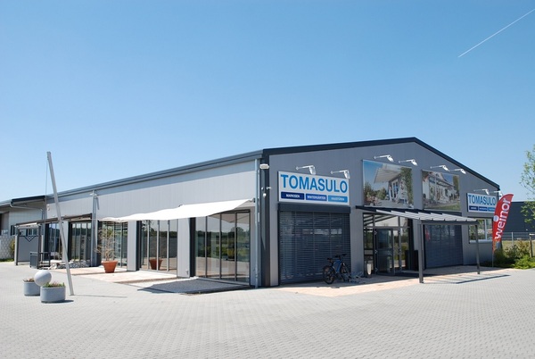 Modernes Firmengebäude von Tomasulo für Markisen, Wintergärten und Haustüren bei Sonnenschein.