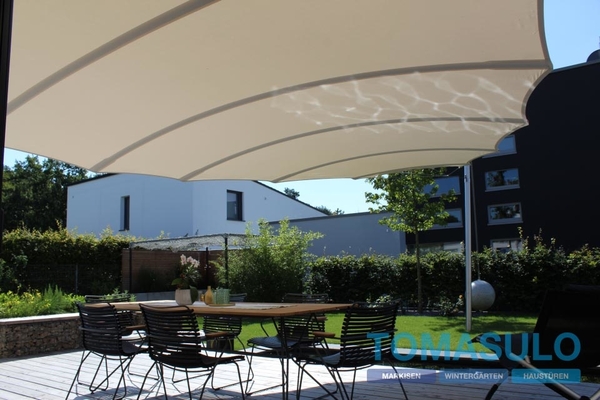 Moderne Terrasse mit Sonnensegel, Gartentisch und Stühlen im stilvollen Außenbereich.