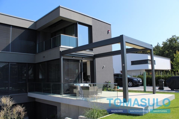 Modernes Einfamilienhaus mit großer Glasfassade und moderner Terrassenüberdachung.